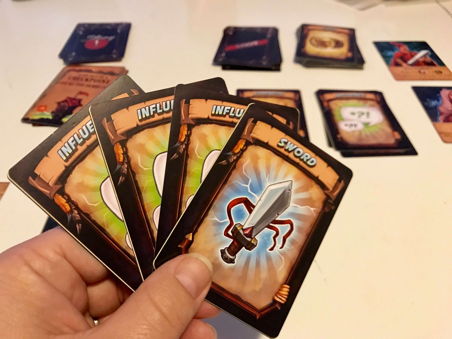 A hand of Influence and Sword cards during play