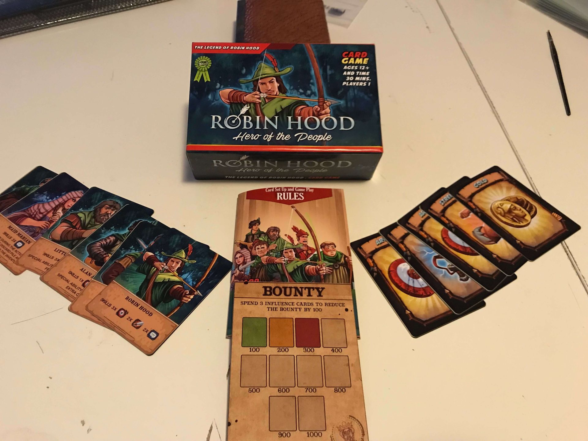 Robin Hood box with character cards, bounty board and resource cards on a table